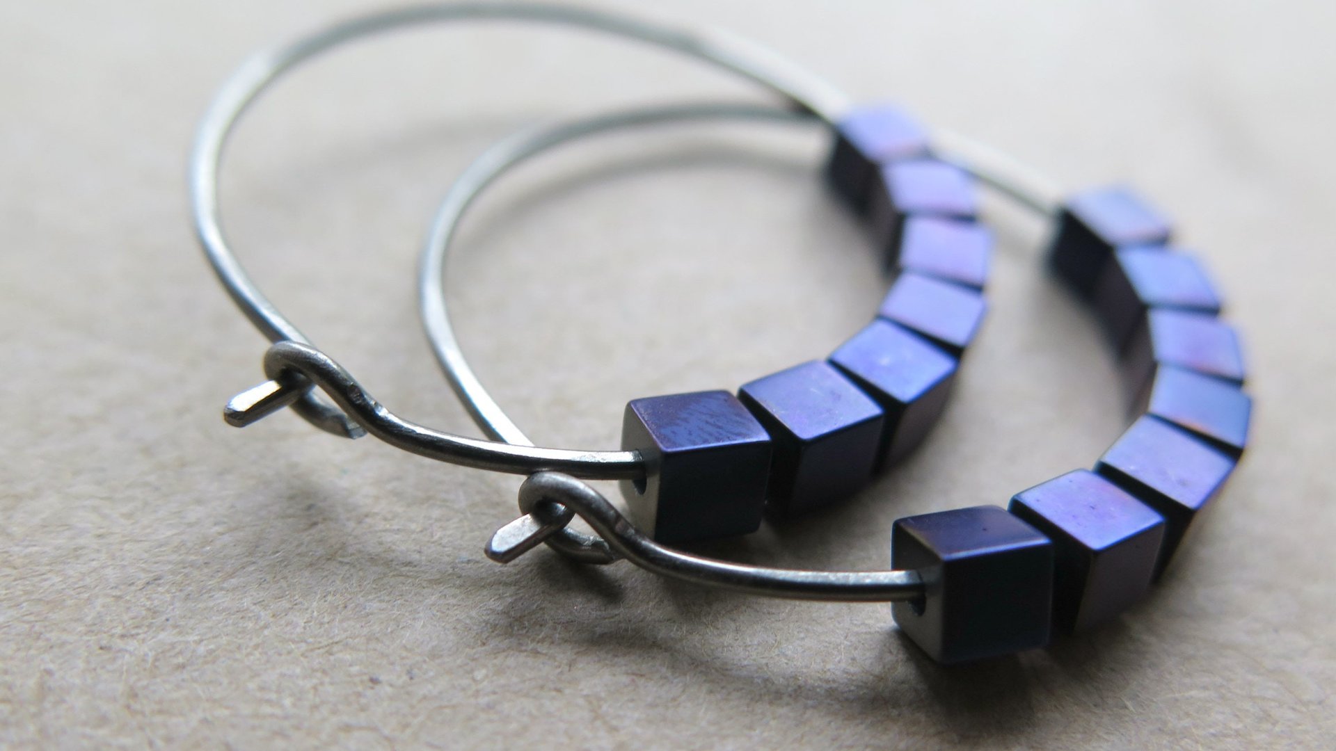 indigo earrings with hematite cubes. hypoallergenic niobium hoops for sensitive ears. modern purple blue jewelry.